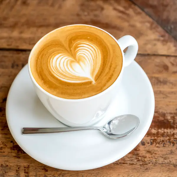 Close up coffee cup with heart latte art on table